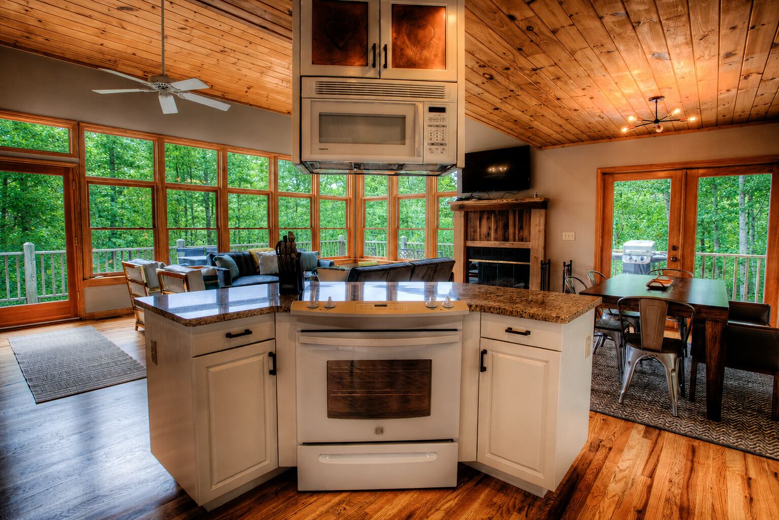 A kitchen with a built-in microwave, oven, and a dining area with a table and chairs.