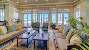 A spacious lobby with a high ceiling, large windows, and comfortable seating areas.