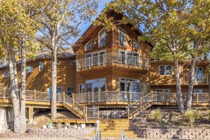 A multi-story log cabin with balconies and a staircase. - Hook Lane - Seven Bedroom House, Sleeps 18 (Camdenton)
