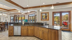 A spacious kitchen with a large island, wooden cabinets, and pendant lighting. - Hook Lane - Seven Bedroom House, Sleeps 18 (Camdenton)