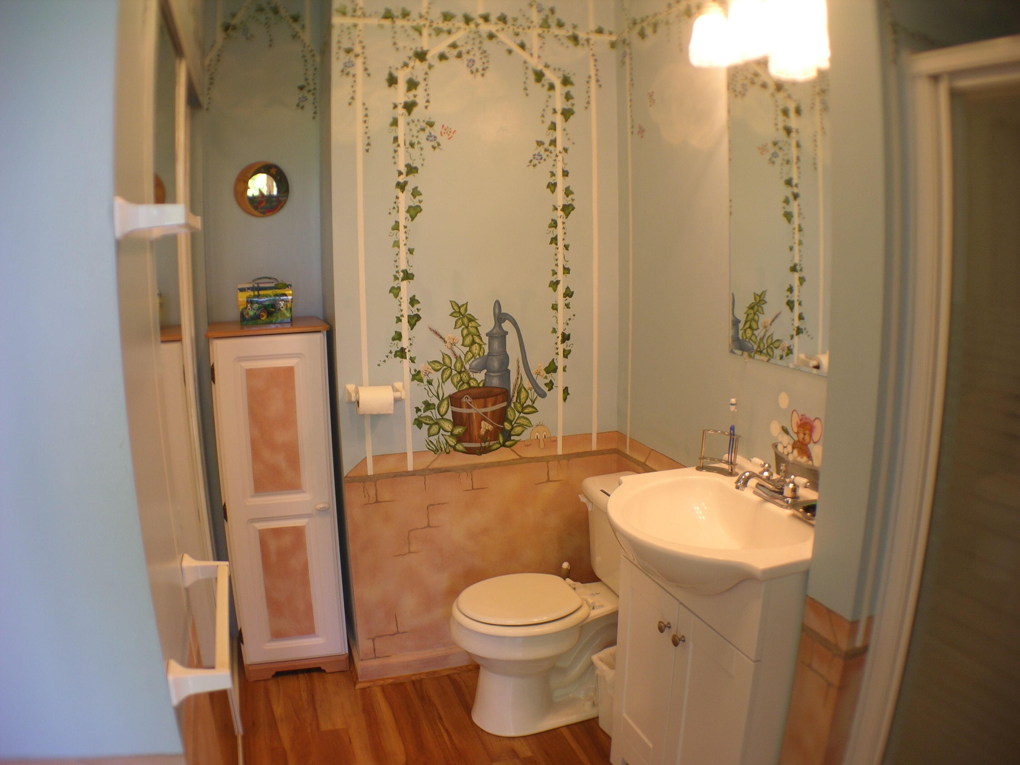 A bathroom with a toilet, sink, and cabinet.