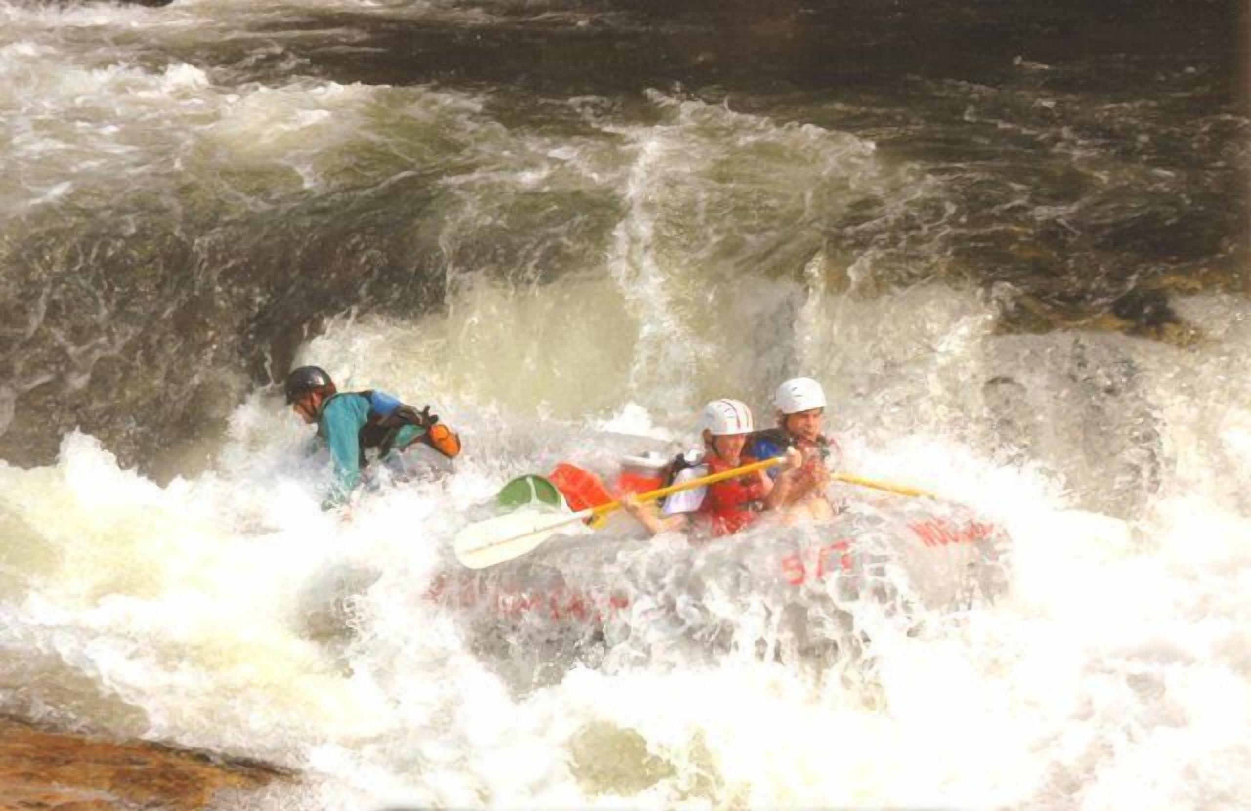 Two people in a kayak navigating a turbulent river.