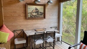 Um interior de madeira com uma mesa de jantar, cadeiras e um quadro na parede.