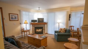 A living room with a fireplace, a sofa, a coffee table, and a television. - Convenient Village Location, Free Parking & WiFi, Jet Tub, Ground Floor (Whistler)