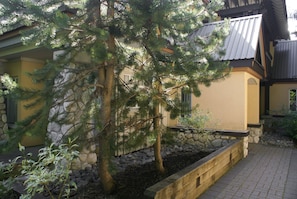 A residential building with a stone wall and a wooden deck.