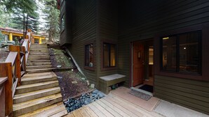 A wooden staircase leading to a house with a porch, a door, and a window. - Cozy, Quiet Mountainside Location, Free Parking & WiFi, Huge Deck (Whistler)