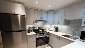 A modern kitchen with stainless steel appliances, light grey cabinets, and a white countertop. - Cozy, Quiet Mountainside Location, Free Parking & WiFi, Huge Deck (Whistler)