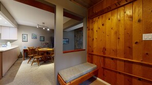 A wooden interior with a dining area, a bench, and a stone wall. - Cozy, Quiet Mountainside Location, Free Parking & WiFi, Huge Deck (Whistler)