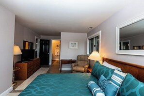 A hotel room with a bed, a TV, a desk, a chair, and a mirror. - Knolls 1111 - Three Bedroom Apartment, Sleeps 8 (Osage Beach)