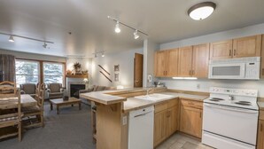 Eine moderne Küche mit Holzausstattung, einem weißen Herd und einer eingebauten Mikrowelle.