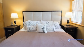 A neatly made bed with a headboard, two bedside tables with lamps, and a window with blinds. - Alpine Greens - Village Shuttle, BBQ, Patio, Free Parking & WiFi (Whistler)
