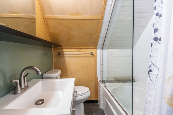 A bathroom with a sink, toilet, and bathtub.