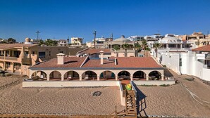 Un bâtiment situé sur la côte, doté d’un toit en tuiles, de plusieurs arcades et d’une rampe d’accès à la plage.