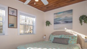 Un dormitorio con una cama, una ventana y un cuadro en la pared.