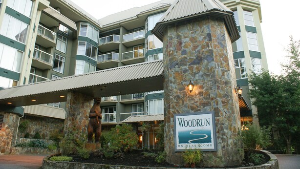 Un hotel de varios pisos con un pilar de piedra y un cartel que dice "Woodrun on Blain Canyon".