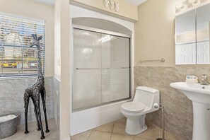 Un baño con ducha, inodoro y lavabo.