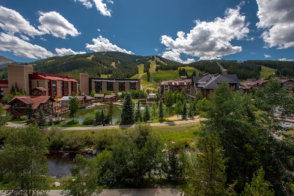 A resort with multiple buildings, a lake, and a mountainous backdrop.
