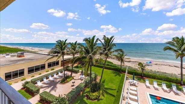 A resort with a pool, palm trees, and a beach view. - Beach Condo/ High-End Finishes/ Island Beach Resort/No Cleaning Fee/ Condo 403 (Jensen Beach)