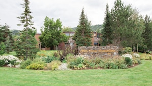 A stone sign with the text "Park Avenue Condominium" surrounded by a landscaped garden with various plants and trees.