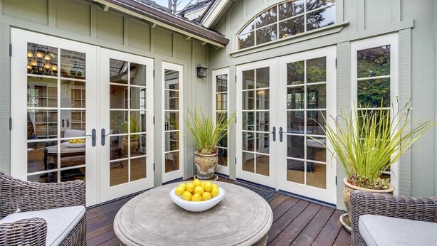 A covered patio with wicker furniture, a round table with a bowl of lemons, and potted plants. - La Vita Dolce – Romantic Carmel-by-the-Sea Cottage Near Beach & Ocean Ave (Carmel by the Sea)