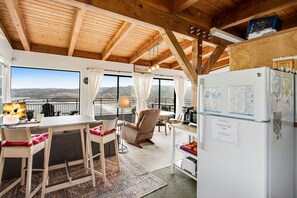 Enjoy a scenic view from the large window in this room, featuring a comfortable armchair and a small table with a lamp.