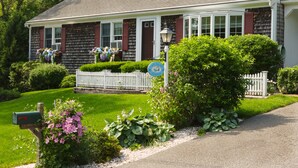 A house with a porch, a mailbox, and a sign that reads "Cape Island Inn."