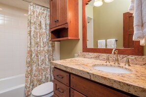 Een bad/douchecombinatie, een haardroger, handdoeken