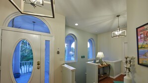 A hallway with arched doorways, a small table with a lamp, and a vase with flowers. - Canal front pool home on the north end of Anna Maria Island (Anna Maria)