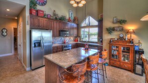 A spacious kitchen with a large island, stainless steel appliances, and wooden cabinets. - Monthly rental getaway on lake LBJ (Kingsland)