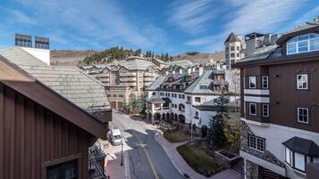 A hotel with multiple buildings, a street with a vehicle, and a clear sky.