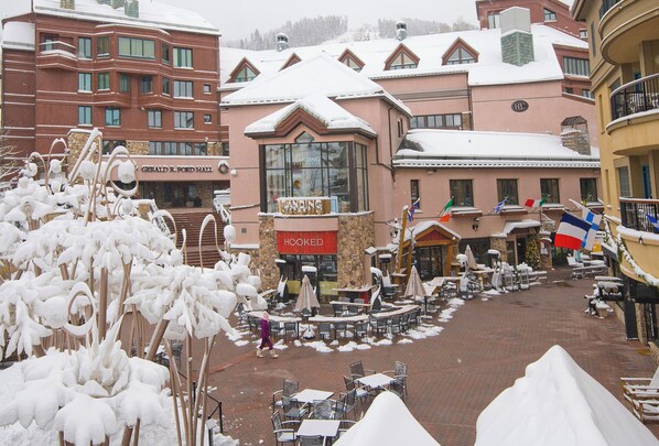 A snow-covered outdoor area with tables and chairs, a building with a 'Hooked' sign, and a 'Gerald R. Ford Hall' sign.