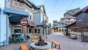 A courtyard with a fire pit, outdoor seating, and a variety of buildings with commercial establishments. - Ski in/Ski out condo w/great views. Overlooking the slopes. Access to hot tub (Winter Park)
