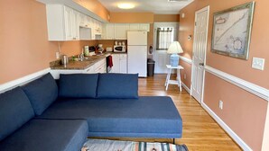 A compact living space with a sofa, kitchenette, and a small dining area.