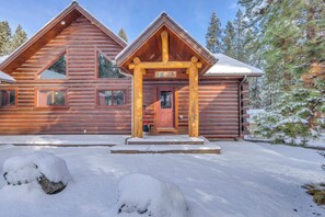 A log cabin with a red door and a sign that reads 'CRANE LANDING.' - Custom Built Log Cabin, Deschutes River, floating (Sunriver)