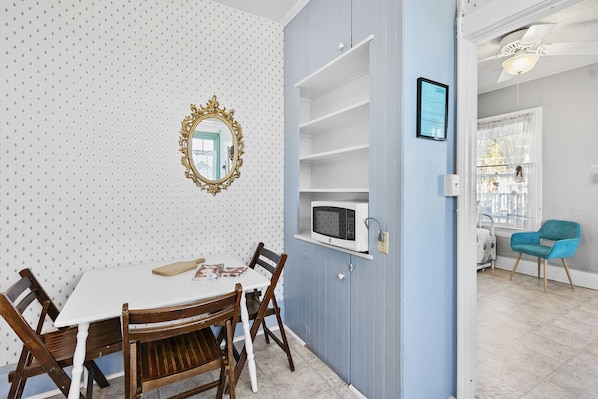 Enjoy meals in this cozy dining area with a table and chairs, microwave, and mirror.