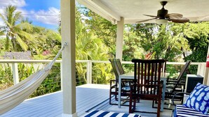A covered outdoor deck with a hammock, lounge chairs, and a table. - Modern 3 Bedroom Family Friendly Kihei Home Near Beach (Kihei)