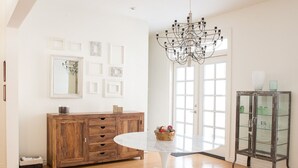 Un comedor con una mesa redonda, un aparador de madera y una vitrina de vidrio.