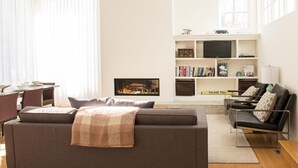 Una sala de estar moderna con un sofá, una mesa de centro, una estantería y una chimenea.