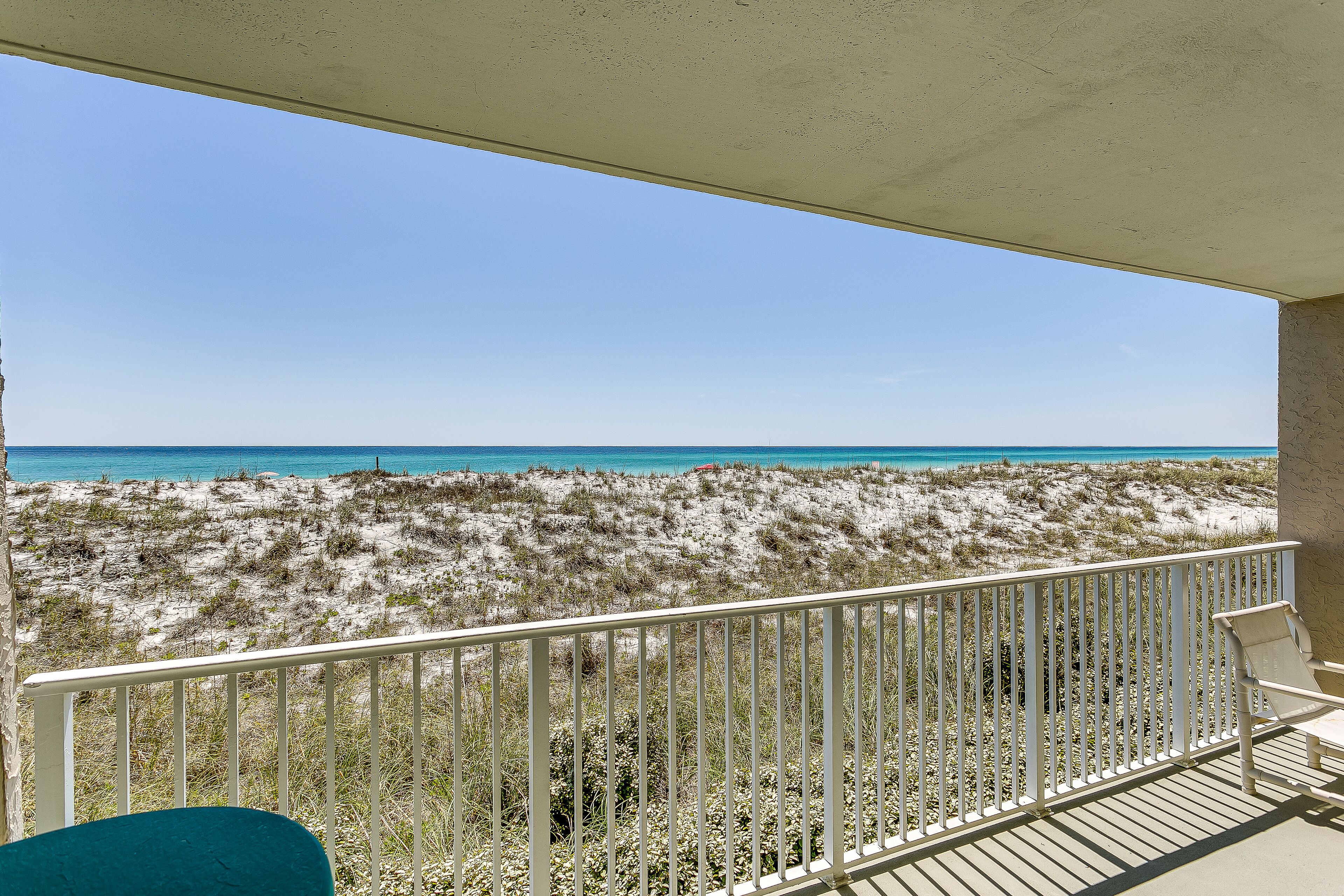 Ein Balkon mit Blick auf Strand und Meer.