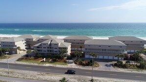 Ein Strandhotel mit mehreren Gebäuden, einer Straße im Vordergrund und dem Meer im Hintergrund.