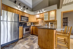 Enjoy cooking in this well-equipped kitchen with a large island, appliances, and ample workspace.