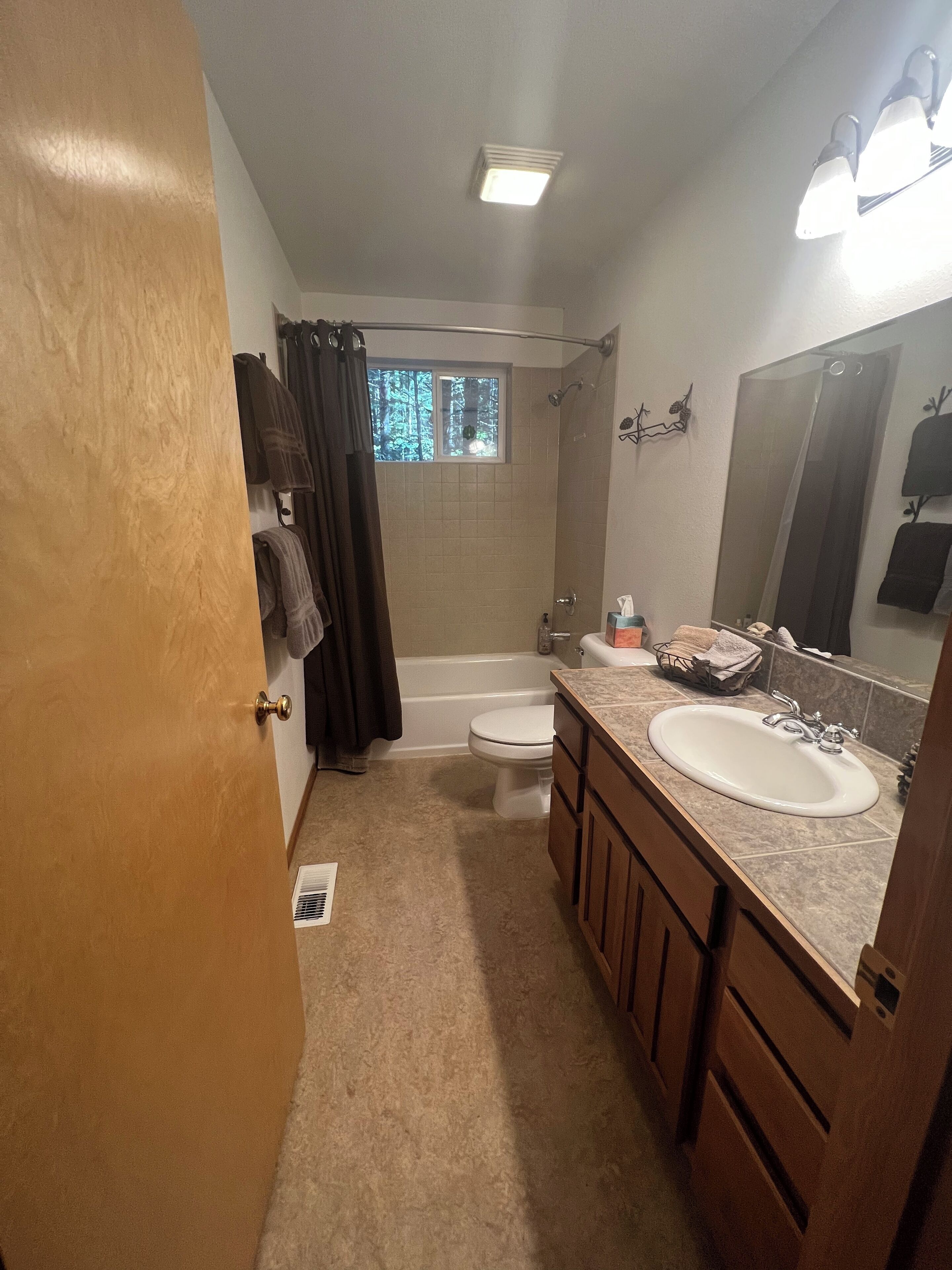 A bathroom with a bathtub, toilet, and sink.