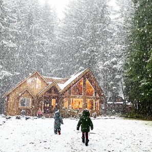 A wooden cabin with a snow-covered roof and large windows, surrounded by trees. - "Elk Hollow" Mountain Home Near Mount Rainier and Crystal Mountain Ski Area, WA  (Enumclaw)