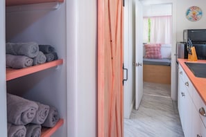 Una habitación de hotel con cama, kitchenette y baño con ducha.