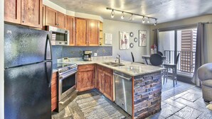 Una cocina moderna con armarios de madera, electrodomésticos de acero inoxidable y una isla grande.