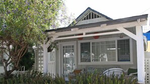 A house with a porch, a window, and a tree. - 334S: Quaint Catalina Cottage, Large Porch, BBQ, WIFI, Min Away from Beach - 334 (Avalon)