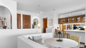 Une cuisine moderne avec des meubles en bois et un coin repas comprenant une table ronde et des chaises.