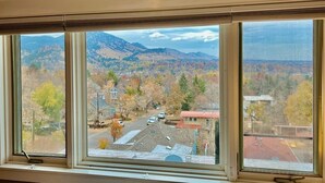 Una ventana con vistas a un pueblo y montañas.