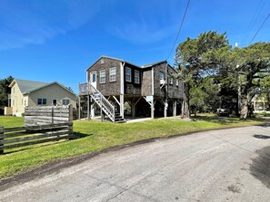Uma casa de dois andares com varanda e escadaria que dá acesso ao andar superior.