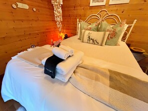 A wooden room with a bed, pillows, and a blanket. - Apple Blossom Cottage Of Gettysburg.  Hot Tub is an Add on Fee (Orrtanna)